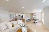 Located at 805 Roosevelt in Boise, Idaho, this thoughtfully designed 2-bedroom, 2-bathroom residence offers a seamless blend of modern aesthetics and functional living. The single-floor layout centers around a bright, open-concept living, dining, and kitchen area unified by light hardwood flooring and a neutral color palette that enhances the sense of space. The kitchen is a standout, featuring warm wood cabinetry with brushed gold hardware, white quartz countertops, a waterfall island with bar seating, glass pendant lighting, and a full suite of stainless appliances with a classic tile backsplash. The dining area is anchored by a striking circular chandelier and receives generous natural light through large windows with clean-lined blinds. The living area is airy and comfortable, complete with a wall-mounted mini-split system for year-round climate control. The primary bedroom offers a calm retreat with plush carpeting, and its en-suite bathroom includes a glass-enclosed shower and a walk-in closet with built-in shelving. The second bathroom features floor-to-ceiling tile, a deep soaking tub, and brushed nickel fixtures. Additional spaces include a pantry, laundry room, hallway, and multiple closets, completing this well-appointed Boise residence.