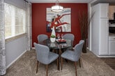 Located at 201 Cairn Cir in Knoxville, Tennessee, this single-floor residence offers a thoughtfully designed layout that balances comfort and functionality throughout. The expansive living room is anchored by plush carpeting, a textured ceiling, and large sliding glass doors that open to a private balcony, flooding the space with natural light and offering pleasant outdoor views. The kitchen features white shaker-style cabinetry, granite-look countertops, a subway tile backsplash, wood-look flooring, and a full suite of stainless steel appliances, providing a clean and contemporary cooking environment. Adjacent to the kitchen, the dining area is defined by a stylish pendant light, a bright window, and a bold accent wall that adds a vibrant focal point to the space. The primary bedroom is generously sized with soft carpeting, large windows, and ample room for substantial furnishings. A second bedroom, accented by warm yellow walls and natural light, offers a cozy and inviting retreat. The bathroom is well-appointed with granite countertops, a wide vanity mirror, white cabinetry for storage, and convenient access to in-unit laundry facilities. Throughout the residence, neutral tones and consistent finishes create a cohesive and welcoming atmosphere.
