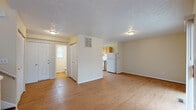 This two-floor residence at 6880 Lefferson Rd in Middletown, Ohio offers a practical and well-organized layout across its two levels. The main living area is expansive and open, finished with warm hardwood-style flooring that extends throughout. A textured ceiling adds visual character to the space, while neutral wall tones create a clean, versatile backdrop. The living area flows naturally toward the kitchen, which features a U-shaped layout with warm wood cabinetry, dark countertops, a double-basin sink, and white appliances including a dishwasher, range, and refrigerator. A window above the sink brings in natural light. A bathroom is conveniently accessible from the main level. The second floor hosts the bedrooms, which are carpeted for comfort. The primary bedroom is notably spacious, featuring vaulted ceilings that lend an airy quality, a large window for natural light, and dual bifold closets offering generous storage. An additional bedroom on this level also features hardwood-style flooring and a bright window. A dedicated laundry area with a checkered tile floor and utility hookups provides added everyday convenience. Throughout, the home maintains a straightforward, functional design suited for comfortable living.