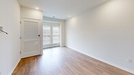 Located at 2500 Kelly Rd in Warrington, PA, this well-appointed one-bedroom, one-bathroom residence offers a thoughtfully designed single-floor layout with a clean, contemporary aesthetic throughout. The open-concept kitchen and living area serves as the heart of the home, featuring light wood-tone flooring, crisp white walls, and recessed lighting. The kitchen is equipped with stainless steel appliances — including a range, over-the-range microwave, and refrigerator — complemented by a mix of white upper cabinetry and warm wood-toned lower cabinets with white quartz-style countertops. The living area provides generous wall space, complete with a pre-installed TV wall mount and dedicated media connections for convenience. The bedroom offers plush carpeting, a large window that allows natural light to fill the space, and a louvered closet door providing dedicated storage. The bathroom is finished with wood-look flooring, a glass-enclosed shower, and brushed nickel hardware and fixtures. A dedicated closet and a clean entryway with keypad entry complete this efficiently organized home. The neutral color palette and modern finishes throughout create a bright, move-in-ready environment suited for comfortable everyday living.