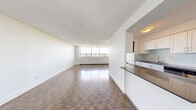 Located at 12-24 Leith Hill Road in Toronto's north end, this well-laid-out three-bedroom, one-bathroom unit offers a comfortable and functional living space across a single floor. Distinctive parquet flooring flows throughout the living areas and bedrooms, lending a warm, classic character to the interior. Large windows in the living room and bedrooms frame open city skyline views, flooding the space with natural light and creating an airy, elevated ambiance.

The kitchen is thoughtfully designed with white shaker-style cabinetry, a light tile backsplash, dark countertops, stainless steel appliances including a refrigerator and dishwasher, and neutral tile flooring — offering ample storage and workspace. A peninsula provides additional counter space and enhances the kitchen's functionality.

The generously sized primary bedroom is a standout, featuring large windows with city views, parquet floors, and direct access to a closet and the bathroom. The additional two bedrooms are well-proportioned, each with windows overlooking the surrounding neighbourhood. One bedroom also includes a mirrored sliding closet.

The bathroom is finished with full white subway tile surround, a soaker tub with shower, a modern vanity with a white countertop, and neutral floor tiles, offering a clean and contemporary feel throughout.