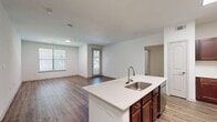 This contemporary 1070 square foot apartment offers a spacious and functional layout with two bedrooms and two bathrooms. The heart of the home is an open-concept kitchen and living area, featuring rich wood cabinetry, stainless steel appliances, and a large center island with a sink, perfect for meal preparation and casual dining. The kitchen flows seamlessly into the living space, ideal for entertaining.

Both bedrooms are generously sized, with the primary bedroom measuring 180 square feet. Each room is equipped with large windows that allow plenty of natural light and are fitted with horizontal blinds for privacy. The bathrooms are modern and well-appointed, with one featuring a combination tub-shower unit and a single vanity with ample counter space.

Throughout the apartment, wood-look flooring adds warmth and durability. The laundry room is conveniently located within the unit, equipped with full-sized appliances. Closet space is plentiful, with wire shelving systems for organization. Ceiling fans in the bedrooms provide additional comfort and air circulation.

The apartment's neutral color palette and clean lines create a blank canvas for personal decorating styles. With its thoughtful design and modern amenities, this apartment offers a comfortable and contemporary living space in the Cool Springs area.
