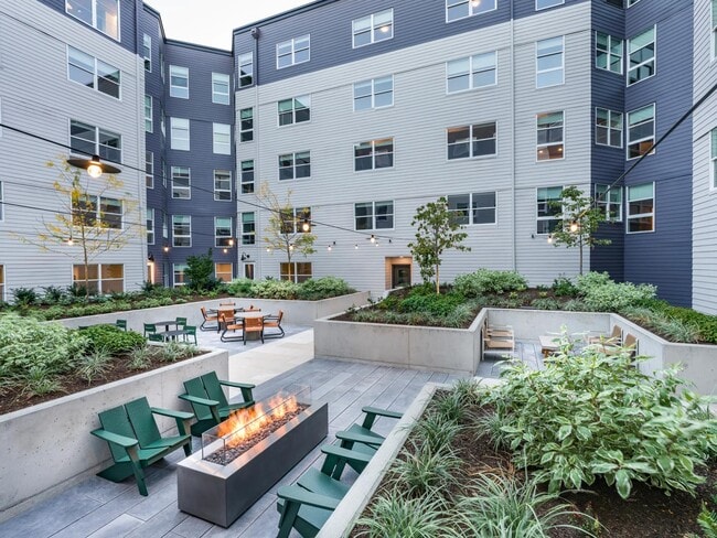 Relax in the meticulously landscaped courtyards offering lounge seating and a cozy fire table. - Modera Woodstock
