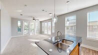 Located in Corinth, TX, this single-story, 2-bedroom, 2-bathroom residence offers a thoughtfully designed layout with modern finishes throughout. The open-concept kitchen and living area serves as the heart of the home, featuring a central island with dark granite countertops, a double stainless steel sink, and elegant pendant lighting. The kitchen is equipped with light wood cabinetry, stainless steel appliances including a refrigerator, electric range, and microwave, as well as track lighting and durable wood-look flooring. The living area flows seamlessly from the kitchen, bathed in natural light from large windows and French doors that open to the patio. A ceiling fan adds comfort to the carpeted living space. The generously sized primary bedroom includes an en-suite bathroom with a dark granite vanity, light wood cabinetry, and wood-look flooring. The second bedroom is equally comfortable, featuring plush carpet and a ceiling fan. Both bathrooms reflect the consistent, contemporary aesthetic found throughout the home. Additional features include multiple closets for ample storage, a dedicated laundry area, two hallways, and a welcoming entrance. The patio extends the living space outdoors, offering a private retreat.