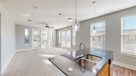 Located in Corinth, TX, this single-story, 2-bedroom, 2-bathroom residence offers a thoughtfully designed layout with modern finishes throughout. The open-concept kitchen and living area serves as the heart of the home, featuring a central island with dark granite countertops, a double stainless steel sink, and elegant pendant lighting. The kitchen is equipped with light wood cabinetry, stainless steel appliances including a refrigerator, electric range, and microwave, as well as track lighting and durable wood-look flooring. The living area flows seamlessly from the kitchen, bathed in natural light from large windows and French doors that open to the patio. A ceiling fan adds comfort to the carpeted living space. The generously sized primary bedroom includes an en-suite bathroom with a dark granite vanity, light wood cabinetry, and wood-look flooring. The second bedroom is equally comfortable, featuring plush carpet and a ceiling fan. Both bathrooms reflect the consistent, contemporary aesthetic found throughout the home. Additional features include multiple closets for ample storage, a dedicated laundry area, two hallways, and a welcoming entrance. The patio extends the living space outdoors, offering a private retreat.