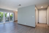 Located at 2 Marina Blvd in Pittsburg, California, this one-bedroom, two-bathroom residence offers a thoughtfully arranged single-floor layout that makes efficient use of its space. Light wood-style flooring runs throughout, complemented by neutral gray walls and textured ceilings that give each room a clean, consistent look.

The galley-style kitchen is well-equipped, featuring white cabinetry extending to the ceiling for ample storage, gray laminate countertops, a double-basin sink, a black refrigerator, a wall oven, a dishwasher, and a gas range. The kitchen opens toward the living area, which is bright and open with sliding glass doors leading to a private balcony overlooking greenery outside.

The bedroom is a comfortable size, offering a sliding-door closet and a window that brings in natural light. An additional closet provides supplemental storage elsewhere in the unit. Two hallways connect the main living spaces to the private areas of the home.

Both bathrooms are finished in clean white tones. One features a soaking tub with a shower combo and a frosted window for natural light, while the other includes a vanity with stone-look countertops and wood-style flooring. The overall ambiance is clean and move-in ready, with a neutral palette suited to a variety of personal styles.