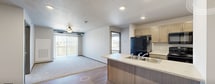 This single-floor apartment at 880 Tenth St in Waukee, Iowa offers a practical and modern layout designed for comfortable everyday living. The open-concept kitchen serves as the heart of the unit, featuring light maple cabinetry, a peninsula with a double sink and light countertops, wood-look vinyl flooring, and a full suite of black appliances including a refrigerator, electric range, and over-the-range microwave. Recessed lighting illuminates the space, which flows seamlessly into the adjacent living area. The bedrooms are carpeted and generously sized, each offering ample wall space and access to closet storage. One bedroom includes a double sliding-door closet, while another features a dedicated walk-in closet with wire shelving. Both bathrooms are finished with wood-look vinyl flooring and include a full tub-shower combination. The primary bathroom includes a vanity with a wood-toned cabinet. A dedicated in-unit laundry room houses a full-size washer and dryer with overhead wire shelving for added storage. Throughout the unit, neutral tones, clean lines, and consistent modern finishes create a cohesive and functional living environment. A large window in one of the bedrooms provides natural light and outdoor views of the surrounding Waukee neighborhood.