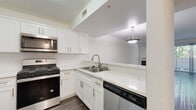 This single-floor residence in Walnut Creek, California offers a clean, modern aesthetic throughout its thoughtfully designed layout. The kitchen is a standout feature, outfitted with crisp white shaker cabinetry, a subway tile backsplash, light quartz countertops, and a full suite of stainless steel appliances including a gas range, built-in microwave, dishwasher, and refrigerator. A pendant light fixture adds a stylish touch above the pass-through counter that connects the kitchen to the main living area. The open living and dining space is bright and airy, featuring rich hardwood-style flooring, neutral white walls, and a fireplace that anchors the room. A pendant light overhead contributes to the welcoming ambiance. The bedroom is generously sized with plush carpeting, mirrored sliding closet doors, and large windows that invite natural light. A sliding glass door provides direct access to a private outdoor area. The bathroom is finished in a clean, contemporary style with wood-style flooring, a white vanity, and a tub-shower combination enclosed by sliding glass doors. The overall design is cohesive and move-in ready, balancing modern finishes with comfortable, functional living spaces.
