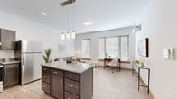Located at 133 S East St in Amherst, MA, this thoughtfully designed one-bedroom, one-bathroom unit offers a modern and efficient layout across a single floor. The open-concept kitchen and living area serves as the heart of the home, anchored by a granite-topped island with dark espresso cabinetry and stylish pendant lighting overhead. The kitchen is fully equipped with stainless steel appliances, including a refrigerator, range, and dishwasher. Light wood-look flooring flows throughout, lending warmth and continuity to the space. Large windows in the living area invite abundant natural light, creating a bright and airy atmosphere ideal for both relaxing and working from home. A ductless mini-split system provides climate control in both the living area and bedroom. The bedroom is a calm, neutral retreat with a window, double-door closet, and its own mini-split unit. The clean, tile-floored bathroom features modern wood-toned cabinetry and a sleek vanity. A stacked in-unit washer and dryer adds everyday convenience. The overall aesthetic is contemporary and clean, with neutral tones and quality finishes throughout.