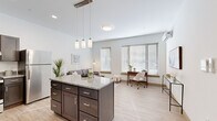 Located at 133 S East St in Amherst, MA, this thoughtfully designed one-bedroom, one-bathroom unit offers a modern and efficient layout across a single floor. The open-concept kitchen and living area serves as the heart of the home, anchored by a granite-topped island with dark espresso cabinetry and stylish pendant lighting overhead. The kitchen is fully equipped with stainless steel appliances, including a refrigerator, range, and dishwasher. Light wood-look flooring flows throughout, lending warmth and continuity to the space. Large windows in the living area invite abundant natural light, creating a bright and airy atmosphere ideal for both relaxing and working from home. A ductless mini-split system provides climate control in both the living area and bedroom. The bedroom is a calm, neutral retreat with a window, double-door closet, and its own mini-split unit. The clean, tile-floored bathroom features modern wood-toned cabinetry and a sleek vanity. A stacked in-unit washer and dryer adds everyday convenience. The overall aesthetic is contemporary and clean, with neutral tones and quality finishes throughout.
