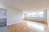 Located at 601 Finch Avenue West in Toronto's North York neighbourhood, this 2-bedroom, 1-bathroom unit offers a practical and comfortable layout spread across a single floor. The living area is a standout feature, characterized by warm parquet flooring in a classic basketweave pattern and large windows that invite generous natural light while offering views of the surrounding neighbourhood. A baseboard heating system runs beneath the windows, ensuring year-round comfort.

The galley-style kitchen is neatly appointed with white cabinetry, marble-look countertops, a double stainless steel sink, and white tile flooring. A stainless steel refrigerator and stove provide modern functionality, and a window at the end of the kitchen brings in additional natural light.

The spacious primary bedroom features the same warm parquet flooring found throughout the unit and offers direct access to both a dedicated closet and the full bathroom. The closet is generously sized with dual hanging rods for ample storage. The second bedroom is similarly bright and well-proportioned.

The bathroom is finished with clean white tile surrounds and includes a full bathtub with an overhead shower. A hallway connects the main living spaces, completing this bright, well-organized unit.