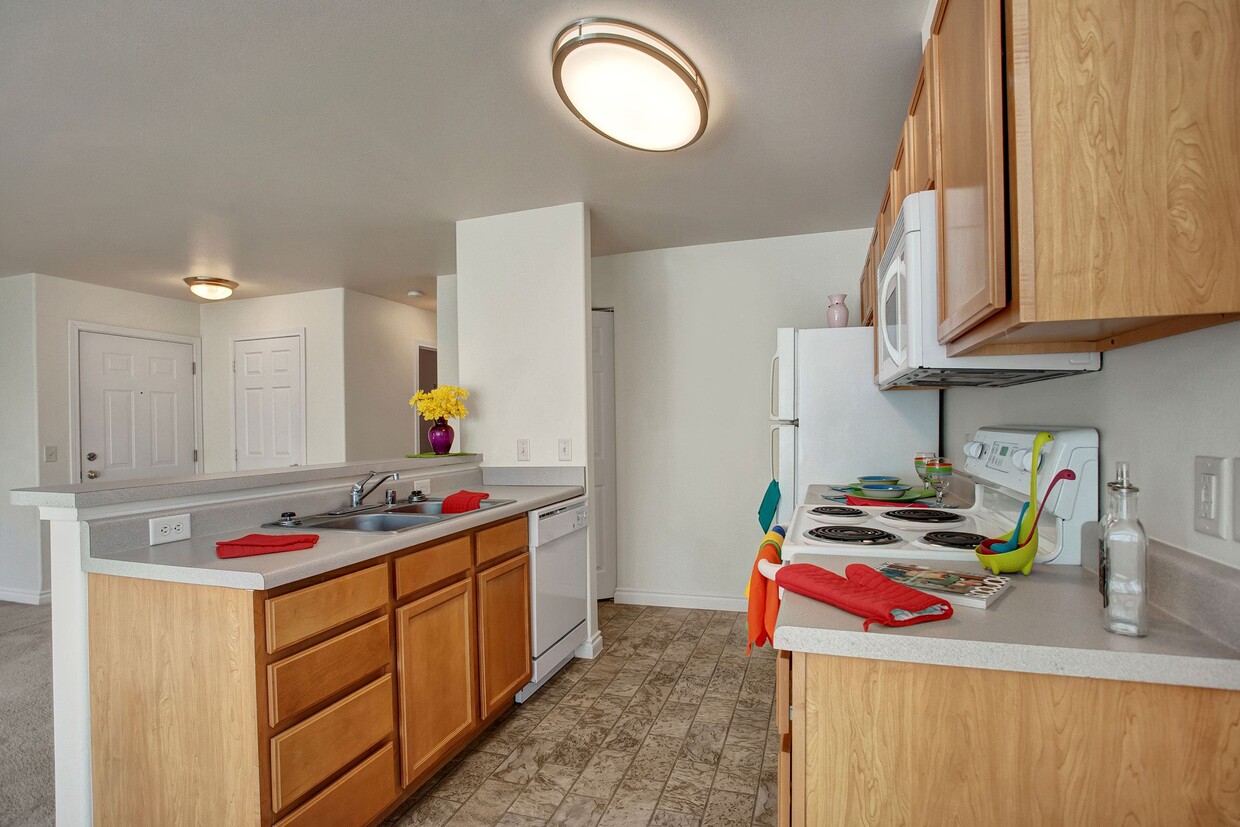 A kitchen with plenty of counter space, a breakfast bar, and lots of cabinet storage space - Lion's Gate