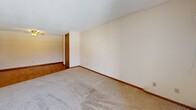 Located at 911 6th Ave NE in Buffalo, Minnesota, this two-bedroom, one-bathroom unit offers a practical and comfortable single-floor layout. The open-concept living, dining, and kitchen area forms the heart of the home, featuring warm hardwood-style flooring, a ceiling fan with light fixture, and a textured ceiling. The kitchen is efficiently designed with white upper cabinetry, rich wood-toned lower cabinets, white appliances including a refrigerator and range, and a stainless steel sink with ample counter space.

The two bedrooms are carpeted and well-lit, each offering natural light through windows with views of surrounding trees. The primary bedroom is generously sized and includes access to a sliding glass door that opens to a private balcony, as well as a wall-mounted air conditioning unit. A spacious walk-in closet with dual hanging rods provides excellent storage within the primary bedroom. Additional closets throughout the unit bring the total to four, ensuring plentiful storage space.

The full bathroom features hardwood-style flooring, a tub-shower combination, a wood-cabinet vanity with a white countertop, and a large mirror. A hallway connects the main living areas to the bedrooms and bathroom, creating a cohesive and functional flow throughout the unit.