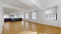 Located at 1001 N Orange St in downtown Wilmington, Delaware, this thoughtfully designed 2-bedroom, 3-bathroom residence offers a clean, contemporary aesthetic across a generously sized single-floor layout. The open-concept living and dining areas are anchored by warm hardwood flooring, crisp white walls, and exposed structural beams that add architectural character. Multiple windows flood the space with natural light, offering views of the surrounding urban streetscape.

The modern kitchen is a standout feature, equipped with stainless steel appliances, sleek dark cabinetry contrasted by bright white upper cabinets, white quartz countertops, and a stainless steel sink beneath a window. A central island provides additional prep and seating space.

Both bedrooms are well-proportioned and bright, each with hardwood floors and access to dedicated closets. The primary bedroom includes a spacious walk-in closet outfitted with built-in shelving and hanging rods for ample storage.

The three bathrooms are finished to a high standard, featuring grey herringbone-patterned tile flooring, floating dark wood vanities with white countertops, modern fixtures, and backlit mirrors. Connecting hallways are clean and functional, completing a well-organized and efficiently planned floor layout.