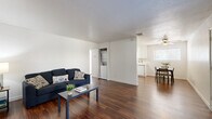 Located at 9012 Casals St in Sacramento, CA, this single-story, 3-bedroom, 2-bathroom home offers a practical and well-organized layout across its single floor. Rich, dark wood-style flooring runs throughout the main living areas, creating a warm and cohesive aesthetic.

The open living room is bright and clean, with white walls and ample space for comfortable seating. It flows naturally toward the in-unit laundry area and connects to the combined dining room and kitchen. The kitchen features white cabinetry, white appliances including a range and refrigerator, a stainless steel sink, and matching wood-style flooring, giving it a tidy, functional feel.

A hallway connects the main living space to the three bedrooms and two bathrooms. The bedrooms are carpeted in a neutral tan tone, offering a softer feel underfoot. The primary bedroom is a comfortable size and includes a ceiling fan and a window that lets in natural light. Additional bedrooms are well-proportioned with clean white walls and closet access. The bathrooms feature white vanities and continue the consistent, clean design found throughout the home.

Additional highlights include a dedicated utility room, a closet for extra storage, and ceiling fans in the bedrooms. The overall design is clean, neutral, and move-in ready.