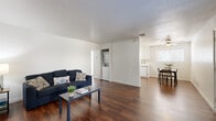 Located at 9012 Casals St in Sacramento, CA, this single-story, 3-bedroom, 2-bathroom home offers a practical and well-organized layout across its single floor. Rich, dark wood-style flooring runs throughout the main living areas, creating a warm and cohesive aesthetic.

The open living room is bright and clean, with white walls and ample space for comfortable seating. It flows naturally toward the in-unit laundry area and connects to the combined dining room and kitchen. The kitchen features white cabinetry, white appliances including a range and refrigerator, a stainless steel sink, and matching wood-style flooring, giving it a tidy, functional feel.

A hallway connects the main living space to the three bedrooms and two bathrooms. The bedrooms are carpeted in a neutral tan tone, offering a softer feel underfoot. The primary bedroom is a comfortable size and includes a ceiling fan and a window that lets in natural light. Additional bedrooms are well-proportioned with clean white walls and closet access. The bathrooms feature white vanities and continue the consistent, clean design found throughout the home.

Additional highlights include a dedicated utility room, a closet for extra storage, and ceiling fans in the bedrooms. The overall design is clean, neutral, and move-in ready.