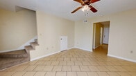 Located at 109 Shemper Dr in Hattiesburg, Mississippi, this two-story, two-bedroom, two-bathroom home offers a practical and comfortable layout spread evenly across two floors. The main level features light ceramic tile flooring throughout the living room, dining room, and kitchen, contributing to a clean, cohesive aesthetic. The living room is a welcoming space highlighted by a ceiling fan with integrated lighting and a staircase leading to the upper level. The kitchen is equipped with white cabinetry and granite-style countertops that line both sides of the room, providing ample prep and storage space. A dedicated laundry room with washer and dryer hookups adds everyday convenience on the main floor. One full bathroom on the main level features a tiled tub-shower combination, a vanity, and dark tile flooring. Upstairs, both bedrooms are finished with soft carpeting and ceiling fans, creating comfortable retreats. The primary bedroom is generously sized with access to a closet. The second bedroom benefits from a window overlooking greenery, bringing in natural light. The second full bathroom upstairs includes a toilet and additional fixtures. Throughout the home, warm beige walls and white trim create a neutral, move-in-ready backdrop.