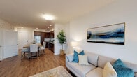 Located along Wagon Wheel Road in Oxnard, California, this single-story residence offers a thoughtfully designed open-concept layout that seamlessly connects the main living areas. The living room is bright and inviting, featuring warm wood-look flooring, crisp white walls, and large windows fitted with blinds that allow natural light to filter through. A framed abstract artwork anchors the space, complemented by a ceiling fan and ample room for comfortable furnishings.

The kitchen is a standout feature, showcasing rich dark-espresso cabinetry extending to the ceiling for generous storage capacity. Granite countertops provide durable workspace, while a full suite of stainless steel appliances—including a gas range, built-in microwave, and refrigerator—caters to everyday cooking needs. Recessed lighting illuminates the space efficiently, and the wood-look flooring continues throughout, maintaining visual continuity. A dining counter with bar seating offers a casual eating option adjacent to the kitchen.

The bedroom is a calm, well-proportioned retreat finished with plush carpet flooring and neutral tones. A window with blinds introduces natural light while maintaining privacy. The overall ambiance of the unit is clean and contemporary, with a cohesive coastal-inspired palette that lends a relaxed, welcoming character throughout.