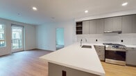 Located at 201 Del Sol Dr in San Diego, CA, this modern single-floor residence showcases a clean, contemporary design throughout. The open-concept kitchen is a standout feature, outfitted with flat-front gray cabinetry, a textured tile backsplash, white quartz countertops, and a large center island with a navy-blue base and undermount sink. Stainless steel appliances, including a gas range and French door refrigerator with ice and water dispenser, complete the well-appointed space. Warm wood-tone flooring flows seamlessly through the kitchen and into the adjacent living area, which is bathed in natural light from large windows and a glass door opening to a private balcony with outdoor views. The bedrooms are bright and airy, each with access to natural light and ample closet space, including a walk-in closet with a full-length hanging rod. The bathrooms are finished with sleek, modern vanities featuring white quartz countertops and backlit mirrors — one with a single undermount sink and one with a dual-sink configuration. A tiled walk-in shower adds to the refined feel. A dedicated laundry room with a full-size Whirlpool front-load washer and dryer provides added convenience. Recessed lighting throughout enhances the bright, polished ambiance of this thoughtfully designed residence.