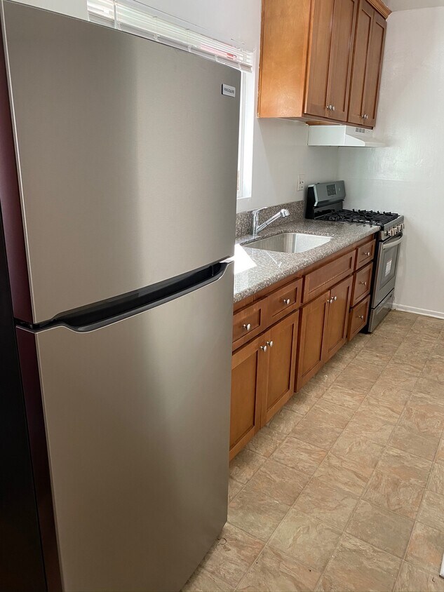 Full kitchen with granite countertops and stainless steel stove and refrigerator - 104 Breeze Ave