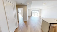 This 680 square foot apartment, situated at 2016 Linkway Blvd in London, Ontario, offers a harmonious blend of modern design and practical living. The open-concept layout maximizes the use of space, seamlessly integrating the kitchen, living, and dining areas. The kitchen is a standout feature, boasting sleek white cabinetry, quartz countertops, and stainless steel appliances, including a full-size refrigerator and range.

The living area is bathed in natural light, thanks to floor-to-ceiling windows that provide stunning views of the surrounding area. These windows not only illuminate the space but also create an airy, expansive feel. The hardwood flooring throughout adds warmth and sophistication to the entire apartment.

The bedroom, measuring 170 square feet, offers ample space and continues the apartment's bright, airy theme with its own large window. The bathroom is a study in modern luxury, featuring a glass-enclosed shower with elegant marble-look tiling and contemporary fixtures.

Attention to detail is evident in the recessed lighting, smooth ceilings, and the overall fit and finish of the space. The neutral color palette provides a versatile backdrop for various décor styles. This thoughtfully designed apartment offers a perfect balance of style, comfort, and functionality in an urban setting.
