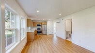Located at 701 Bowling Ave in Nashville's desirable Green Hills neighborhood, this 2-bedroom, 1-bathroom unit offers a clean, modern aesthetic throughout. Light-toned hardwood flooring flows seamlessly across the entire living space, enhancing the bright and airy atmosphere created by abundant natural light from multiple windows.

The open kitchen and living area forms the heart of the unit, featuring light wood cabinetry, white quartz countertops, a subway tile backsplash, and a full suite of stainless steel appliances including a refrigerator, range, microwave, and dishwasher. A window above the sink brings in additional natural light and outdoor views.

The living room is generously proportioned with large windows overlooking the surrounding greenery, creating a welcoming and light-filled environment. Both bedrooms are comfortably sized, each with hardwood floors, crisp white walls, and windows that frame pleasant outdoor views. The spacious primary bedroom provides a comfortable retreat.

The bathroom is finished to a high standard, featuring a vanity with a white countertop, modern hardware, and a frameless glass-enclosed shower with clean white tile. A staircase with rich dark wood treads and white balusters connects to additional areas of the building. The overall design is cohesive, contemporary, and move-in ready.