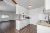 Located in Redondo Beach, CA, this well-appointed one-bedroom, one-bathroom unit offers a functional and comfortable single-floor layout. The open-concept living and kitchen area serves as the heart of the home, featuring warm wood-style flooring that flows throughout the main living spaces. The kitchen is equipped with white cabinetry, granite-style countertops, a gas range, a double-basin stainless steel sink, and a full-size refrigerator — providing ample storage and workspace. A peninsula counter connects the kitchen to the living area, enhancing the open feel of the space. Large windows fitted with vertical blinds invite generous natural light into the living room, creating a bright and airy atmosphere. The bedroom is a comfortable retreat with plush carpeting, a ceiling fan with light fixture, and a large window offering outdoor views. Two closets provide convenient storage throughout the unit. The bathroom features a full tub and shower combination with tile surround, a vanity with storage, and a window for natural ventilation. A hallway connects the main living areas to the bedroom and bathroom, completing the efficient and practical floor plan.
