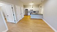 This 590 square foot apartment offers a thoughtful layout with two bedrooms and one bathroom. The space is characterized by its modern design and efficient use of space. The kitchen is a standout feature, boasting white cabinetry, stainless steel appliances, and a subway tile backsplash. The countertops appear to be a sleek, dark material, possibly granite or quartz, providing an elegant contrast.

Throughout the apartment, light wood flooring creates a warm and inviting atmosphere. The primary bedroom, measuring 120 square feet, likely accommodates a queen-sized bed comfortably. Large windows in the bedrooms allow for ample natural light, enhancing the sense of space.

The bathroom showcases a contemporary design with a floating vanity, large mirror, and a combination tub-shower unit. Light-colored tile flooring and white fixtures contribute to a clean, spa-like ambiance.

The apartment's neutral color palette, predominantly featuring whites and light grays, creates a bright and airy feel throughout. Modern lighting fixtures, including pendant lights and a circular ceiling fixture in the kitchen, add both functionality and style. The space also includes climate control with a wall-mounted air conditioning unit visible in one of the rooms.