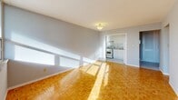 Located on the 14th floor at 80 St Clair Avenue East in the heart of midtown Toronto, this one-bedroom, one-bathroom unit offers a practical and well-organized layout. Warm parquet flooring runs throughout the space, lending a classic character that ties each room together cohesively.

The entrance leads into a hallway that opens into a bright combined living and dining area. Large windows flood the space with natural light, casting warm patterns across the parquet floors. The living area connects to a separate kitchen, which features white cabinetry, white appliances, and a clean, functional design. A balcony extends the living space outdoors, offering views of the surrounding urban neighbourhood.

The bedroom is a comfortable, well-proportioned room with its own natural light from a window and generous closet storage provided by a full-width sliding louvred closet. Soft grey walls throughout the unit create a calm, neutral palette. Additional closet space is found in the hallway, providing practical storage solutions.

The bathroom is finished with clean white tile surrounding a full bathtub and shower combination, complemented by a mirrored vanity. With three closets total across the unit, storage is a notable strength of this layout. This unit presents a tidy, move-in-ready space in a prime midtown Toronto location near transit, dining, and greenery.