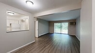 Located at 2217 Tanglewood Dr in Hammond, Indiana, this single-floor, 2-bedroom, 2-bathroom residence offers a well-organized layout with a comfortable, functional design throughout. The living room is a highlight of the space, featuring rich hardwood-style flooring, a baseboard heating system, and a large sliding glass door fitted with vertical blinds that floods the room with natural light and provides pleasant views of the surrounding greenery. A pass-through window connects the kitchen to the living and dining areas, enhancing the open feel of the space. The kitchen is outfitted with white shaker-style cabinetry, granite-look countertops, a stainless steel sink, and a range with an overhead ventilation hood — all set on light wood-style flooring. Both bedrooms are generously proportioned, featuring the same hardwood-style flooring, neutral-toned walls, and baseboard heating. The spacious primary bedroom includes a dedicated closet for ample storage. The two bathrooms are clean and functional — one features a soaking tub with elegant marble-patterned surround panels and chrome fixtures, while the other includes a wood-toned vanity, mirror with vanity lighting, and a toilet. A hallway connects all rooms, completing this practical and tidy single-level layout.