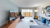 This single-floor 1-bedroom, 1-bathroom residence offers a thoughtfully designed layout that maximizes both comfort and functionality. The kitchen is a standout feature, equipped with warm honey-toned shaker cabinetry, stainless steel appliances including a gas range and full-size refrigerator, and light quartz countertops. A peninsula with bar seating provides additional prep space and a casual dining option, while a window allows natural light to fill the area. Wood-style flooring grounds the kitchen and flows cohesively into the adjoining dining space. The living room is bright and welcoming, featuring soft carpeting, a soothing sage-green accent wall, and large sliding glass doors that open to a private balcony with outdoor views. The bedroom is generously sized with plush carpeting, a large window overlooking a green outdoor setting, and a spacious closet. Neutral tones throughout create a calm and restful atmosphere. The full bathroom includes a tub-shower combination with chrome fixtures, a vanity with quartz countertop, and wood-style flooring that ties the space together. Overall, this residence presents a clean, modern aesthetic with practical features suited for comfortable everyday living.