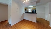 Located at 956 Manchester Ct in Charlottesville, Virginia, this single-floor residence offers a well-organized layout with a practical blend of comfort and functionality. The living area is bright and open, featuring warm wood-style flooring, crown molding, and a sliding glass door that floods the space with natural light while providing access to the outdoors. Adjacent to the living area is a dedicated dining space, connected to the kitchen via a peninsula-style breakfast bar with pendant lighting above.

The kitchen is efficiently designed with ample warm-toned wood cabinetry, dark granite-style countertops, and a full suite of black appliances including a range, microwave, refrigerator, and sink — all tied together by the same wood-style flooring that runs throughout the common areas.

The bedrooms are carpeted for comfort, each offering a calm, neutral palette and natural light through window blinds. Closet space is provided via bifold-door closets. The bathrooms are clean and functional, featuring wood-look flooring, a shower-tub combo with safety grab bars, a single-sink vanity with wood cabinetry, white countertops, and a mirrored medicine cabinet — details that reflect a thoughtful, accessible design throughout the home.