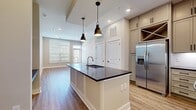 This 970 square foot single-story residence offers a thoughtful blend of comfort and functionality. The home comprises 2 bedrooms, 3 bathrooms, a living room, and a kitchen, all efficiently arranged to maximize the available space. The primary bedroom, measuring 180 square feet, provides a generous retreat within the compact layout.

The property boasts a modern aesthetic, as evidenced by the image of one of its rooms. Light wood-style flooring extends throughout, creating a warm and inviting atmosphere. The walls are painted in a neutral tone, enhancing the sense of spaciousness and allowing for versatile decor options.

Large windows, including a prominent one visible in the image, flood the space with natural light, creating a bright and airy ambiance. The addition of recessed lighting ensures adequate illumination during evening hours. A notable feature is the glass door leading to a balcony, offering outdoor access and potentially scenic views.

The room shown appears to be either the living area or one of the bedrooms, showcasing the property's contemporary design sensibilities. Clean lines, minimalist trim, and the absence of ornate features contribute to its modern appeal. This efficiently designed space exemplifies urban living, where every square foot is thoughtfully utilized to create a comfortable and stylish home.