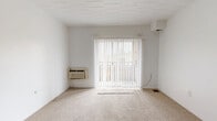 Located at 58 S Fremont Ave in Bellevue, PA, this 2-bedroom, 1-bathroom unit is laid out across a single floor, offering a practical and well-organized floor plan. The generously sized primary bedroom is a standout feature, providing ample living space, soft wall-to-wall carpeting, a large sliding glass door with vertical blinds that floods the room with natural light, and a wall-unit air conditioner. A wide double louvered-door closet offers substantial storage. The second bedroom is bright and comfortable, featuring a large window with exterior views and matching carpet throughout. The galley-style kitchen is efficiently arranged with warm wood cabinetry lining both sides, white appliances including a refrigerator and stove, and a window at the far end that brings in natural light. The bathroom is well-appointed with a dual-sink vanity set into warm wood cabinetry, a mirrored medicine cabinet, and classic pink tile wainscoting with mosaic tile flooring. The living area is open and airy, featuring a ceiling fan, neutral carpeting, and a textured ceiling. The overall ambiance is clean, neutral, and move-in ready, offering a solid foundation for personalization.