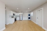 Located at 18940 NE Miami Ct in Miami, FL, this single-story 2-bedroom, 1-bathroom home offers a clean, modern aesthetic throughout. Light-toned luxury vinyl plank flooring runs continuously across the entire floor plan, lending a cohesive and airy feel to the space.

The open-concept kitchen and living area forms the heart of the home. The kitchen is outfitted with high-gloss white cabinetry extending to the ceiling, white quartz countertops, a subtle tile backsplash, and a full suite of stainless steel appliances including a refrigerator, range, microwave, and dishwasher. A stacked washer and dryer unit is neatly integrated into a dedicated alcove within the living area, adding practical convenience.

A hallway connects the living space to both bedrooms and the bathroom. The primary bedroom is generously sized, featuring multiple windows with blinds that allow natural light, a ceiling fan, and a built-in closet with louvered bi-fold doors. The second bedroom also benefits from natural light through dual windows. The bathroom features a soaking tub framed by floor-to-ceiling marble-style tile and a natural light window, creating an elevated, spa-like finish.