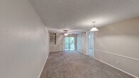 Located at 2121 Dickson Drive in Austin, TX, this 2-bedroom, 1-bathroom single-floor residence offers a practical and comfortable layout. The open living and dining area is a welcoming central space featuring plush carpet flooring, a ceiling fan with integrated lighting, a pendant light over the dining area, and built-in wall shelving ideal for display or storage. A sliding glass door floods the room with natural light and provides direct access to an outdoor balcony with tree-lined views, creating a bright and airy atmosphere throughout.

Both bedrooms continue the carpeted flooring and are each equipped with ceiling fans and windows that frame lush greenery outside, offering a calm, natural ambiance. Each bedroom benefits from its own dedicated closet for organized storage. The bathroom is a functional full bath featuring a tub-shower combination, wood-toned cabinetry overhead for additional storage, and durable wood-look vinyl flooring. A hallway connects the main living spaces to the bedrooms and bathroom, maintaining an efficient flow throughout the unit. The kitchen completes the layout, providing essential workspace. This residence offers a straightforward, well-organized floor plan in a convenient Austin location.