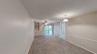 Located at 2121 Dickson Drive in Austin, TX, this 2-bedroom, 1-bathroom single-floor residence offers a practical and comfortable layout. The open living and dining area is a welcoming central space featuring plush carpet flooring, a ceiling fan with integrated lighting, a pendant light over the dining area, and built-in wall shelving ideal for display or storage. A sliding glass door floods the room with natural light and provides direct access to an outdoor balcony with tree-lined views, creating a bright and airy atmosphere throughout.

Both bedrooms continue the carpeted flooring and are each equipped with ceiling fans and windows that frame lush greenery outside, offering a calm, natural ambiance. Each bedroom benefits from its own dedicated closet for organized storage. The bathroom is a functional full bath featuring a tub-shower combination, wood-toned cabinetry overhead for additional storage, and durable wood-look vinyl flooring. A hallway connects the main living spaces to the bedrooms and bathroom, maintaining an efficient flow throughout the unit. The kitchen completes the layout, providing essential workspace. This residence offers a straightforward, well-organized floor plan in a convenient Austin location.