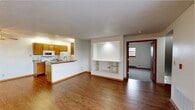 This single-floor residence offers a practical and well-organized layout that maximizes everyday comfort. The open-concept living area serves as the heart of the home, featuring warm hardwood-style flooring, neutral white walls, and a built-in display niche with integrated shelving and accent lighting — a standout architectural detail that adds character to the space. A ceiling fan overhead enhances air circulation throughout the common area.

The galley-style kitchen is efficiently designed with ample warm-toned oak cabinetry, granite-patterned countertops, a stainless steel sink, and a full suite of white appliances including a range, microwave, refrigerator, and dishwasher. A peninsula counter connects the kitchen to the living area, creating a natural flow ideal for everyday living and entertaining.

A sliding glass door floods an additional living or dining space with natural light and provides direct access to an outdoor patio, offering a seamless indoor-outdoor connection. The bedrooms are carpeted and bright, each featuring natural light from gridded windows and wood-trimmed doors, with at least one room offering a sliding closet. The full bathroom is clean and functional, complete with an oak vanity, a large mirror with overhead lighting, and a tub-shower combination.
