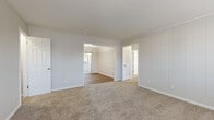 Located at 4883 Roswell Rd NE in Atlanta's 30342 zip code, this single-floor home offers four bedrooms and two bathrooms across a comfortable, functional layout. The kitchen is a standout feature, showcasing rich dark mahogany cabinetry, light granite countertops, a tile backsplash, black appliances, and a peninsula with additional counter space — all set on durable wood-look flooring. The living and bedroom areas are finished with neutral wall-to-wall carpeting, creating a warm and quiet atmosphere throughout. The spacious primary bedroom includes two closets for ample storage and connects to adjacent spaces via open doorways. Additional bedrooms are bright and well-proportioned, each featuring natural light from blinds-covered windows. Both bathrooms maintain a clean, crisp aesthetic with white subway tile, pedestal sinks, wood-look flooring, and mirrored medicine cabinets — one with a tub/shower combo and one with a walk-in shower. The home also includes a dedicated laundry area and a hallway connecting the rooms efficiently. The overall palette of soft whites, warm neutrals, and rich wood tones gives the home a clean, move-in ready feel.