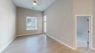 Located at 2120 North Brevard Street in Charlotte, NC, this well-appointed one-bedroom, one-bathroom unit offers a thoughtfully designed layout with modern finishes throughout. The open-concept living and kitchen area features light wood-look flooring, soaring ceilings, and recessed lighting that create a bright, airy atmosphere. The kitchen is a standout, equipped with dark espresso cabinetry, granite countertops, stainless steel appliances including a refrigerator, range, and microwave, and a central island with a pendant-lit overhang and undermount sink — ideal for both cooking and casual dining. The living area benefits from large windows that invite natural light and views of the surrounding community. The bedroom offers plush carpeting, a generous footprint, and a window providing additional natural light. The bathroom is elegantly finished with a dual-sink granite vanity, dark cabinetry, a large mirror with overhead lighting, and a tiled tub/shower combination. A dedicated closet provides practical storage. Neutral gray tones throughout the unit lend a clean, contemporary feel that is both inviting and versatile. This unit combines functional design with upscale finishes in a prime Charlotte location.