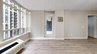 Located on a high floor at 151 Beecroft Road in North York, Toronto, this one-bedroom, one-bathroom unit offers a well-organized layout with a clean, modern aesthetic throughout. Light hardwood-style flooring flows seamlessly across the living spaces, complemented by neutral warm-grey walls that create a bright and cohesive atmosphere.

The open-concept kitchen and living area serves as the heart of the unit. The kitchen is efficiently designed with white cabinetry, granite countertops, a white subway tile backsplash, and a full suite of stainless steel appliances including a refrigerator, stove, and dishwasher. A peninsula counter adds functional workspace and visual separation from the living area.

The living room benefits from expansive floor-to-ceiling windows that frame sweeping city views, flooding the space with natural light. A glass door opens directly onto the private balcony, extending the living area outdoors with additional urban views.

The bedroom is a comfortable, well-proportioned retreat featuring the same hardwood-style flooring, a sliding mirrored closet, and access back to the main living space. The bathroom is finished with clean white tile, a soaker tub with overhead shower, and chrome fixtures, offering a simple and functional design. Track lighting throughout the unit adds a modern touch to the overall presentation.
