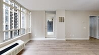 Located on a high floor at 151 Beecroft Road in North York, Toronto, this one-bedroom, one-bathroom unit offers a well-organized layout with a clean, modern aesthetic throughout. Light hardwood-style flooring flows seamlessly across the living spaces, complemented by neutral warm-grey walls that create a bright and cohesive atmosphere.

The open-concept kitchen and living area serves as the heart of the unit. The kitchen is efficiently designed with white cabinetry, granite countertops, a white subway tile backsplash, and a full suite of stainless steel appliances including a refrigerator, stove, and dishwasher. A peninsula counter adds functional workspace and visual separation from the living area.

The living room benefits from expansive floor-to-ceiling windows that frame sweeping city views, flooding the space with natural light. A glass door opens directly onto the private balcony, extending the living area outdoors with additional urban views.

The bedroom is a comfortable, well-proportioned retreat featuring the same hardwood-style flooring, a sliding mirrored closet, and access back to the main living space. The bathroom is finished with clean white tile, a soaker tub with overhead shower, and chrome fixtures, offering a simple and functional design. Track lighting throughout the unit adds a modern touch to the overall presentation.