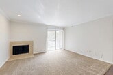 Located at 9600 Golf Lakes Trail in Dallas, TX, this one-bedroom, one-bathroom unit offers a practical and comfortable single-floor layout. The living room serves as the heart of the space, featuring crown molding, a tile-surround wood-burning fireplace, and a sliding glass door that floods the room with natural light and provides access to an outdoor balcony. Plush carpeting flows throughout the main living and bedroom areas, while rich hardwood-style flooring carries through the entry, kitchen, and bathroom. The galley-style kitchen is well-appointed with dark espresso cabinetry, light countertops, recessed lighting, and stainless appliances, with an adjacent pantry and in-unit laundry for added convenience. A dedicated dining room connects the kitchen to the living area seamlessly. The spacious bedroom includes a ceiling fan, a natural light-filled window, and direct access to multiple closets as well as the full bathroom. The bathroom features a full tub-shower combination, dark wood cabinetry, and matching hardwood-style flooring. With three closets throughout, this unit offers excellent storage. Crown molding and ceiling fans add classic finishing touches throughout the space.
