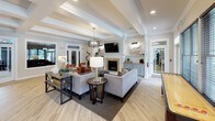 Located at 101 Chesapeake Ridge in North East, Maryland, this single-floor clubhouse serves as a sophisticated community gathering space. The grand entrance foyer immediately sets the tone with bold navy blue walls, soaring wood-paneled ceilings with exposed beam detailing, warm travertine tile flooring, and a branded "Chesapeake Ridge" welcome mat — all framing a set of elegant glass-paneled entry doors that flood the space with natural light. White structural columns add a classic architectural touch throughout.

The reception area flows seamlessly into a well-appointed leasing office featuring dark wood cabinetry, warm accent lighting, and window treatments that balance privacy with natural illumination. Adjacent to the office, a spacious lounge area invites residents to relax, with plush neutral sofas and accent chairs arranged around a fireplace framed by a tile surround. A wall-mounted flat-screen TV anchors the seating area, while light hardwood flooring and coffered ceilings add refinement throughout.

The lounge extends into a recreation zone with a full billiards table and bar-height counter seating along the windowed wall. The fully equipped kitchen area features a large white quartz island, sleek gray cabinetry, stainless steel appliances, and polished pendant lighting — ideal for community events and gatherings.