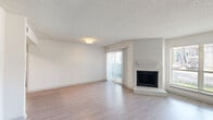 Located at 12000 Fleming Dr in Houston, TX, this single-floor, one-bedroom, one-bathroom unit offers a well-organized layout with a thoughtful mix of comfort and functionality. The bright living room serves as the heart of the space, featuring light wood-style flooring, a textured ceiling, and a classic brick fireplace with a stepped mantle that adds a charming focal point. Large sliding glass doors with vertical blinds open to a private patio, filling the room with natural light and providing easy outdoor access. A large window further enhances the airy, open feel of the living area. The bedroom is a comfortable size and includes a sliding glass door to its own outdoor access point, along with ample closet space — three closets are found throughout the unit. The kitchen is positioned conveniently off the main living area and is visible in the floorplan alongside dedicated laundry space, adding everyday practicality. Throughout, the clean white walls and consistent flooring create a cohesive, neutral palette that is easy to personalize. The unit's efficient layout makes smart use of every square foot, delivering a cozy yet complete living experience in a residential Houston neighborhood.