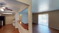 This single-floor residence in Sherman offers a functional and comfortable layout designed for everyday living. The open living area features hardwood-style flooring and a large sliding glass door fitted with vertical blinds, allowing generous natural light and outdoor views. A distinctive wood-topped pass-through bar connects the living space to the kitchen, creating an open, connected feel between the two areas. The kitchen is well-equipped with white cabinetry, speckled countertops, a double stainless steel sink, black appliances including a refrigerator and dishwasher, and hardwood-style flooring that continues the home's cohesive aesthetic. The bedrooms are carpeted and generously sized, each featuring ceiling fans with light fixtures. One bedroom includes a walk-in closet, providing ample storage, while another offers a window with outdoor views. The two bathrooms each include a full tub-shower combination with white tile surround and chrome fixtures. One bathroom features a vanity with speckled countertops and a large mirror. Throughout the home, textured ceilings and neutral wall tones create a clean, move-in ready atmosphere well-suited for a variety of living arrangements.