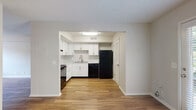 This two-floor residence offers a well-organized layout designed for comfortable everyday living. The kitchen is a standout feature, outfitted with crisp white shaker cabinetry, brushed nickel hardware, marble-look countertops, and a full suite of black appliances including a range, dishwasher, and refrigerator. Wood-look flooring runs throughout the main living areas, lending warmth and visual continuity to the open-concept lower level. A set of French doors in one of the main rooms floods the space with natural light and provides views of the surrounding greenery, enhancing the bright, airy atmosphere. A half bathroom on the main level features a pedestal sink with brushed nickel fixtures and a mirrored medicine cabinet. Upstairs, the bedrooms are finished with plush carpeting and feature windows with blinds that offer natural light and outdoor views. A full bathroom serves the upper level, complete with a shower-tub combination and wood-look flooring. Textured ceilings are present throughout, and neutral wall tones create a clean, versatile backdrop across all rooms. The thoughtful two-floor layout provides a clear separation between living and sleeping areas, making this a functional and inviting space.
