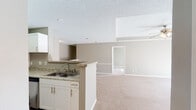 Located at 11205 S Course View in Franklin, Tennessee, this single-story residence offers a well-organized, open-concept floor plan finished in neutral taupe tones throughout. The kitchen is a functional highlight, featuring white shaker-style cabinetry, granite countertops, a subway tile backsplash, stainless steel appliances including an electric range and over-the-range microwave, and wood-look luxury vinyl plank flooring. A peninsula with a double-basin sink connects the kitchen to the main living area, which transitions into generously sized, carpeted spaces ideal for dining and lounging.

The living room is distinguished by a tray ceiling with a ceiling fan and light kit, adding architectural interest and depth. Natural light filters in through multiple windows fitted with horizontal blinds. Bedrooms are carpeted and well-proportioned, each with windows providing natural light. At least one bedroom includes access to a walk-in closet outfitted with wire shelving systems.

The bathrooms feature granite-topped white vanities and wood-look flooring. One bathroom includes a tub-shower combination with classic tile accenting, while another offers a more streamlined layout. The overall ambiance is clean, bright, and move-in ready.