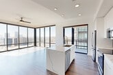 Located along Peachtree Road NW in Atlanta's vibrant Buckhead corridor, this thoughtfully designed 4-bedroom, 2-bathroom residence offers a compelling blend of modern aesthetics and functional living. The single-floor layout is anchored by an open-concept kitchen and living area that immediately impresses with dramatic floor-to-ceiling windows, flooding the space with natural light and framing sweeping views of the Atlanta skyline and surrounding cityscape.

The kitchen is a standout feature, showcasing a marble-veined waterfall island with an undermount sink, sleek white cabinetry reaching toward the ceiling, a dark tile backsplash, and a full suite of stainless steel appliances. Rich hardwood flooring flows throughout the main living areas, complementing the clean, bright aesthetic.

The four bedrooms offer a mix of hardwood and plush carpet flooring. The primary bedroom boasts its own floor-to-ceiling window wall with iconic skyline views, a ceiling fan, and access to a walk-in closet with built-in wire shelving, accessed via a stylish sliding barn door. The bathrooms are finished in a crisp, modern palette with white quartz countertops, light-toned tile flooring, and tub-shower combinations. Distinctive paneled doors in bold slate blue add a refined design touch throughout.