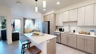 Located at 8901 Holly Ave NE in Albuquerque, New Mexico, this thoughtfully designed one-bedroom, one-bathroom residence offers a cohesive and modern living experience across a single floor. The open-concept layout seamlessly connects the kitchen, dining, and living areas, creating an efficient yet airy flow throughout the space.

The kitchen is a standout feature, showcasing light wood cabinetry, a classic tile backsplash, stainless steel appliances including a gas range, refrigerator, dishwasher, and microwave, as well as a central island with pendant lighting overhead — ideal for casual dining or meal prep. Light-toned luxury vinyl plank flooring runs throughout, enhancing the bright and clean aesthetic.

The living room offers a comfortable retreat with natural light streaming through large windows dressed in elegant draping curtains, alongside direct access to a private patio. The bedroom is a calm and well-proportioned sanctuary, featuring a ceiling fan, a wide window with outdoor views, and access to a generously sized walk-in closet equipped with full-length hanging rods and overhead shelving. The bathroom features a wide vanity with a white countertop and a large mirror. The overall ambiance is clean, contemporary, and refined.